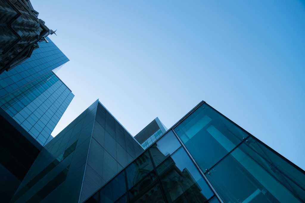 Modern glass skyscrapers against a clear blue sky representing commercial enterprise
