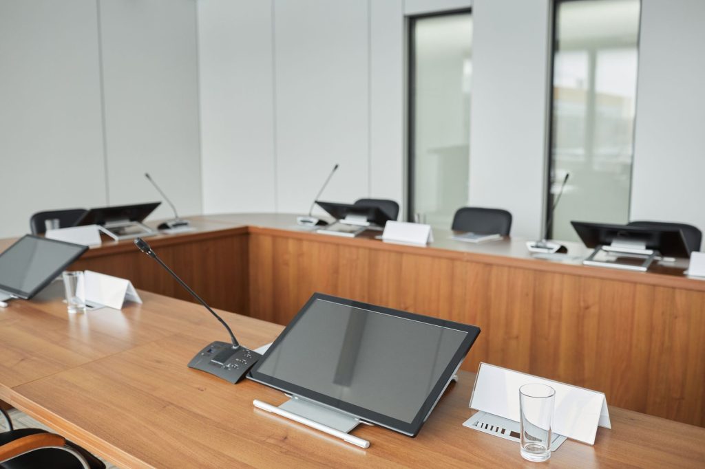Spacious modern conference room with microphones and monitors on a wooden table